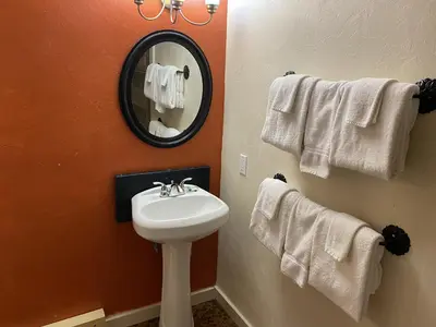 a bathroom with a sink and a mirror and towels at The Viking Lodge - Downtown Winter Park Colorado in Winter Park