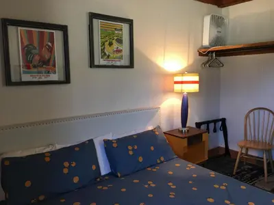 a bedroom with a bed and a lamp and a chair at The Viking Lodge - Downtown Winter Park Colorado in Winter Park