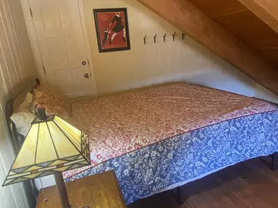 a small bed in a room with a lamp at The Viking Lodge - Downtown Winter Park Colorado in Winter Park