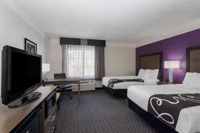 a hotel room with two beds and a flat screen tv at La Quinta by Wyndham Denver Boulder - Louisville in Louisville