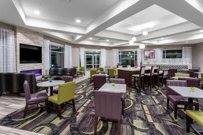 a restaurant with tables and chairs and a bar at La Quinta by Wyndham Denver Boulder - Louisville in Louisville