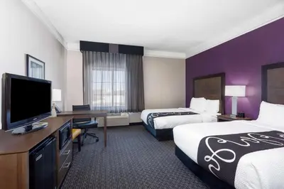 a hotel room with two beds and a flat screen tv at La Quinta by Wyndham Denver Boulder - Louisville in Louisville
