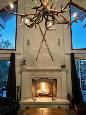 a living room with a fireplace with a antler chandelier at Forest Feeling in Dillon