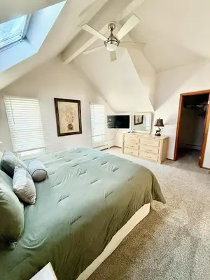 a bedroom with a large bed and a ceiling fan at Forest Feeling in Dillon
