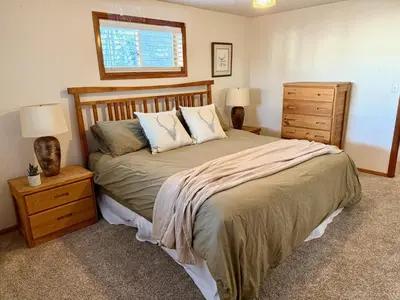 a bedroom with a bed with two night stands and two lamps at Forest Feeling in Dillon