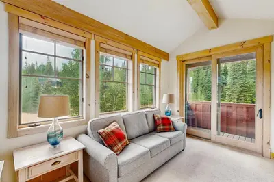 a living room with a couch and windows at Easy Bend Elegance in Silverthorne
