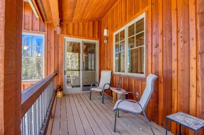 a porch with two chairs and a table and windows at Easy Bend Elegance in Silverthorne