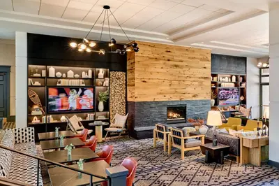 a lobby with a fireplace and tables and chairs at Omni Interlocken Hotel in Broomfield