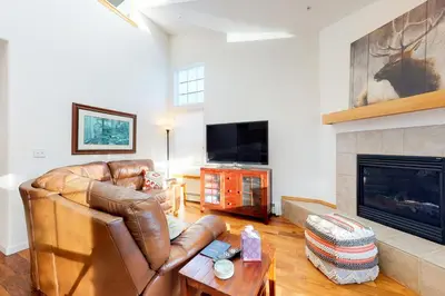 a living room with a leather couch and a fireplace at Gore Trail Getaway in Silverthorne