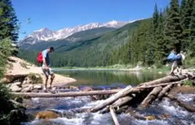 two people crossing a log bridge over a river at Candlewood Suites Denver Northeast - Brighton by IHG in Brighton