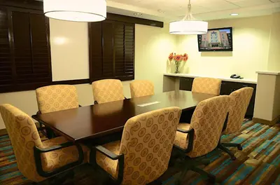 a conference room with a wooden table and chairs at Candlewood Suites Denver Northeast - Brighton by IHG in Brighton