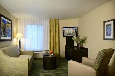 a hotel room with a couch and a tv at Candlewood Suites Denver Northeast - Brighton by IHG in Brighton