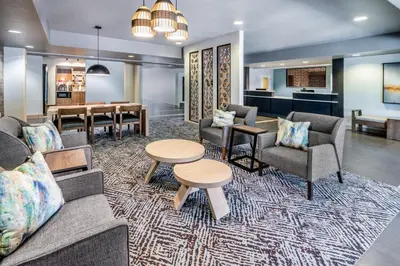 a living room with a couch and chairs and a table at Candlewood Suites Denver Northeast - Brighton by IHG in Brighton
