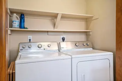 a laundry room with two washing machines and shelves at Elk Haven in Estes Park