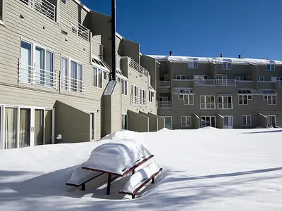 a snow covered bench in front of a building at Crestview Place Unit 507 in Winter Park
