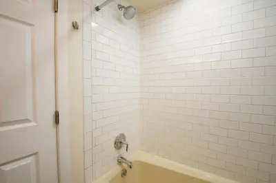 a bathroom with a tub and a shower with white tiles at Crestview Place Unit 507 in Winter Park
