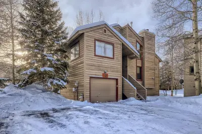 a wooden house with a garage in the snow at Mountainside 753 Home in Frisco