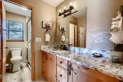 a bathroom with a sink and a toilet and a mirror at Mountainside 753 Home in Frisco