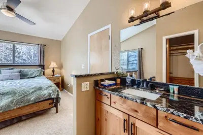 a bedroom with a bed and a sink and a mirror at Mountainside 753 Home in Frisco