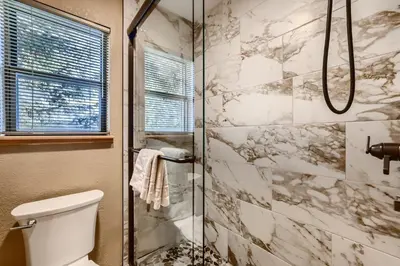 a bathroom with a toilet and a glass shower at Mountainside 753 Home in Frisco