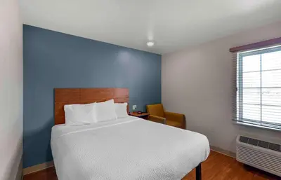 a bedroom with a large bed and a blue wall at Extended Stay America Suites - Denver - Airport in Aurora