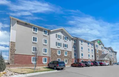 a large apartment building with cars parked in a parking lot at Extended Stay America Suites - Denver - Airport in Aurora