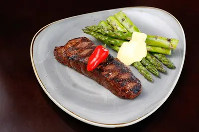 a plate of food with meat and asparagus and sauce at Four Seasons Hotel Denver in Denver