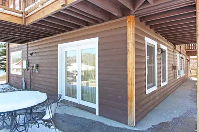 a side of a house with a table and a patio at Little Matterhorn 17A Condo in Estes Park