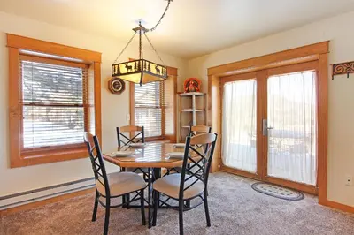 a dining room with a table and chairs and windows at Little Matterhorn 17A Condo in Estes Park