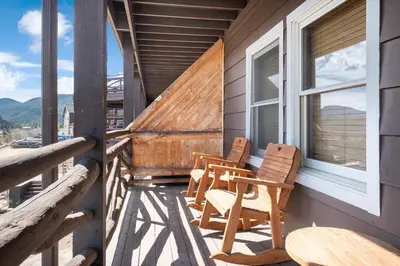 a balcony with two chairs and a table and a window at Powell Peak 104 Condo in Estes Park