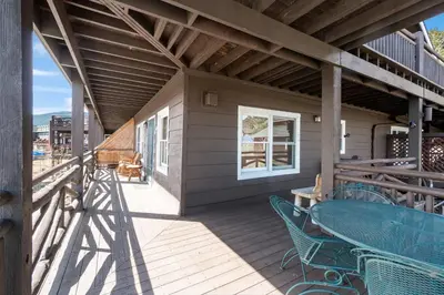 a patio with a table and chairs on a deck at Powell Peak 104 Condo in Estes Park