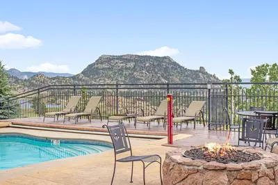a patio with chairs and a fire pit next to a pool at Powell Peak 104 Condo in Estes Park