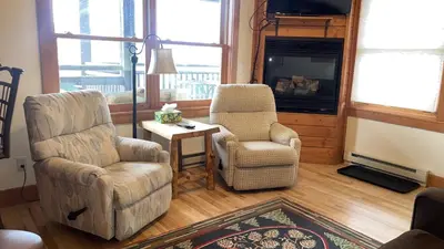 a living room with two chairs and a television at Powell Peak 104 Condo in Estes Park
