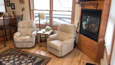 a living room with two chairs and a fireplace at Powell Peak 104 Condo in Estes Park