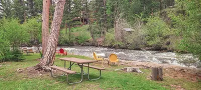 a picnic table and chairs next to a river at Idlewilde by the River in Estes Park