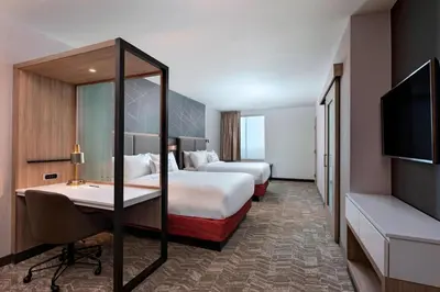 a hotel room with two beds and a desk and a tv at SpringHill Suites by Marriott Denver West/Golden in Lakewood