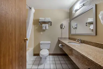 a bathroom with a toilet and a sink and a mirror at Comfort Inn Denver Southeast Area in Aurora