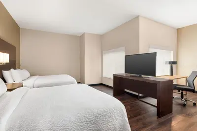 a hotel room with two beds and a desk with a television at Residence Inn Denver Cherry Creek in Denver