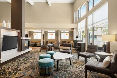 a lobby with chairs and tables and a fireplace at Residence Inn Denver Cherry Creek in Denver