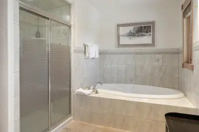 a bathroom with a tub and a glass shower at Mountain Peak Home in Tabernash