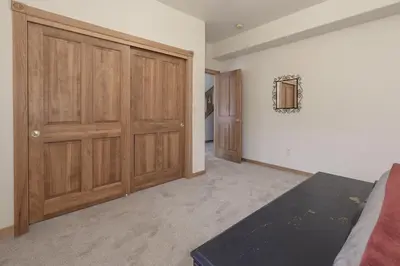 a bedroom with wooden closet doors and a bed at Mountain Peak Home in Tabernash