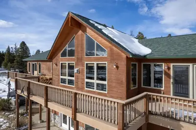 a house with a deck with snow on it at Mountain Peak Home in Tabernash