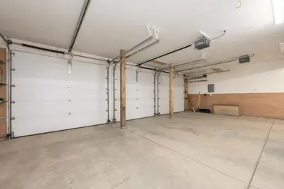 a garage with white doors and a concrete floor at Mountain Peak Home in Tabernash