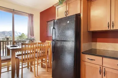 a black refrigerator in a kitchen with a table at Chiefs Head Peak 21B Condo in Estes Park