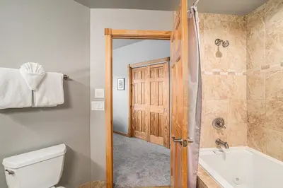 a bathroom with a toilet and a tub and a shower at Nakai Peak 41B Condo in Estes Park