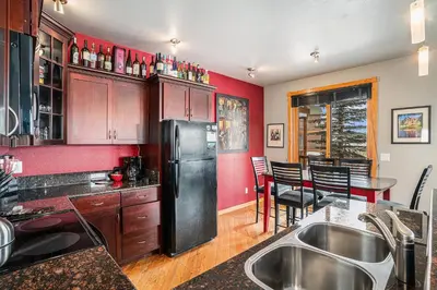 a kitchen with red walls and a black refrigerator at Nakai Peak 41B Condo in Estes Park