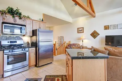 a kitchen with stainless steel appliances and a living room at Mount Enentah 37 Condo in Estes Park