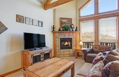 a living room with a tv and a fireplace at Mount Enentah 37 Condo in Estes Park