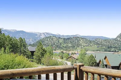 a view of a lake and mountains from a wooden railing at Horsetooth Peak 26C Condo in Estes Park
