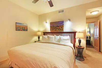 a bedroom with a large white bed with two lamps at Horsetooth Peak 26C Condo in Estes Park